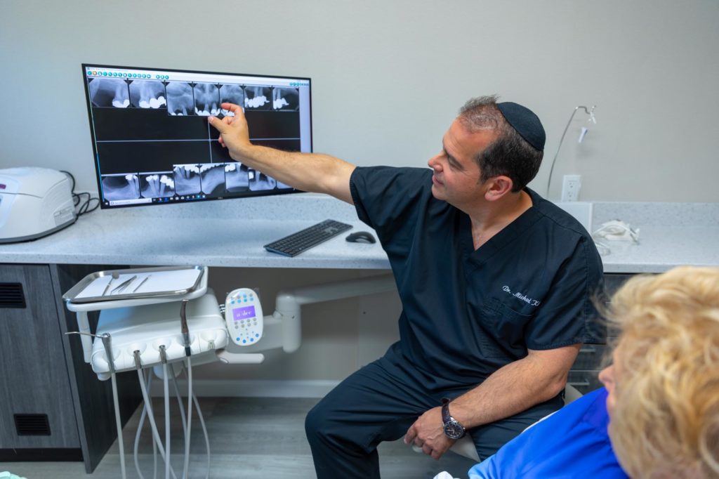 Dr Klein talking to patient about dental implants Cedarhurst, NY