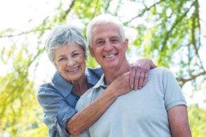 Elderly couple smiling after their dental implant procedure