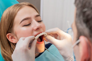 an image of a patient getting treated by a skilled prosthodontist for her full mouth dental implants after she has been administered sedation dentistry for her procedure.